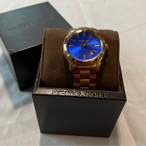 Womens Michael Kors Rose gold metal watch with cobalt blue face.